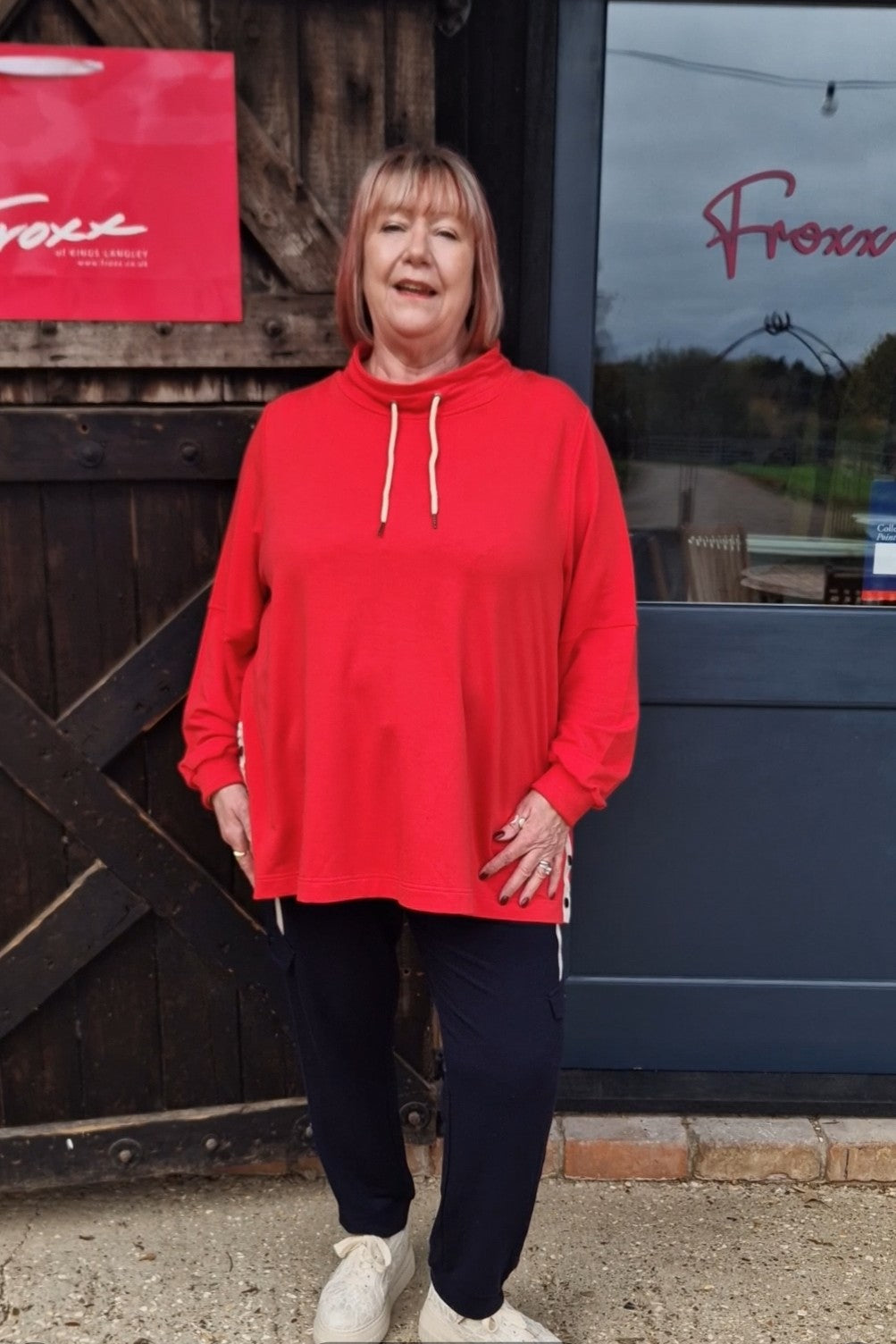 Our YouTube model Babs standing in front of our shop wearing Pont Neuf Elefa leisure top in red for Froxx Clothing plus sizes